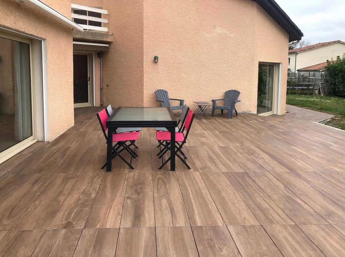Terrasse extérieure avec piscine rectangulaire aux margelles en pierre claire, entourée d'un dallage moderne